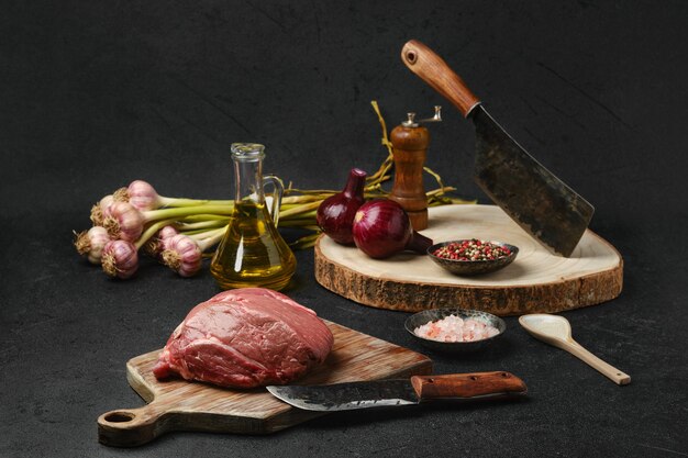 Rauw rundvlees petite entrecote met ingrediënten op zwarte achtergrond