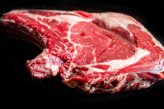 Rauw rundvlees prime rib geïsoleerd op zwarte achtergrond