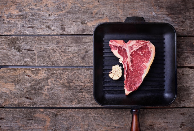 Rauw T-bone steak op ijzeren grillpan