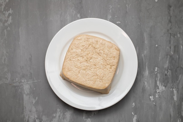 Rauw tofu blok op wit schaaltje op keramiek