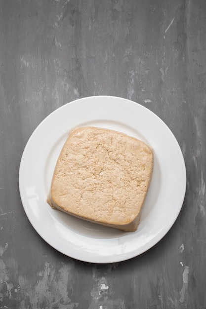 Foto rauw tofu blok op wit schaaltje op keramiek