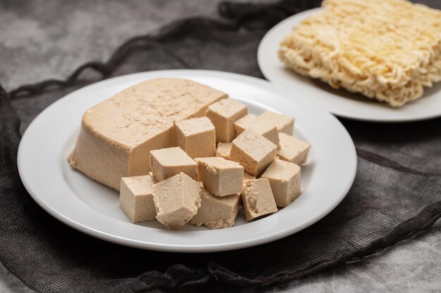 Rauw tofu blok op wit schaaltje op keramiek