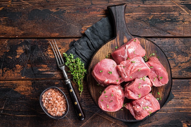 Rauw varkensvlees gesneden ossenhaas filet vlees voor medaillons steaks op een houten snijplank Houten achtergrond Bovenaanzicht