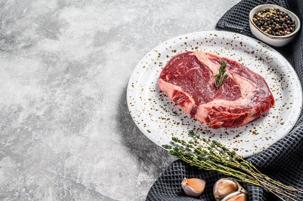 Rauw vers vlees Ribeye Steak met kruiden op snijplank. Rib eye biefstuk. bovenaanzicht. Kopieer ruimte