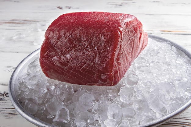 Foto rauw visvlees op ijs rood vlees liggend op plaat basisingrediënt voor sushi dik en sappig