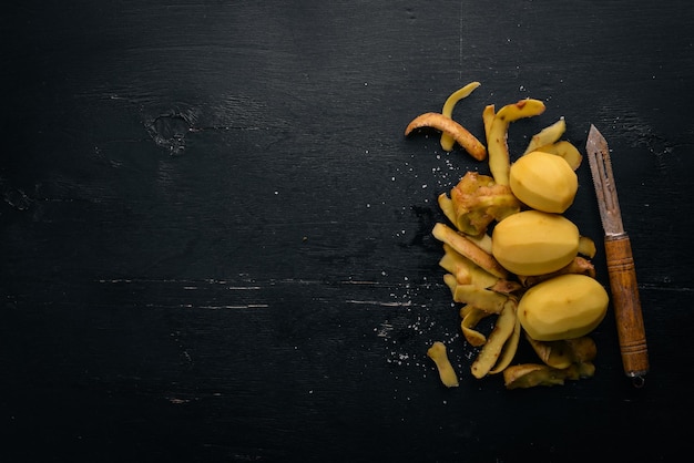 Rauwe aardappelen op een zwarte houten achtergrond Koken Vrije ruimte voor tekst Bovenaanzicht