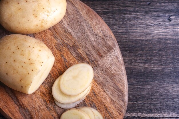 Rauwe aardappelschijfjes op een houten bord