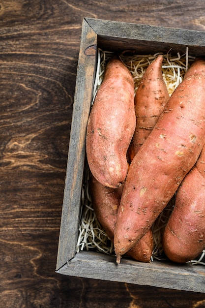 Rauwe batata Zoete aardappel op houten tafel. Houten achtergrond. Bovenaanzicht.