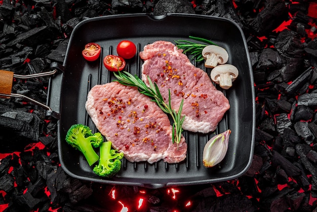 Rauwe biefstuk met groenten en kruiden op een grillpan biologisch vlees