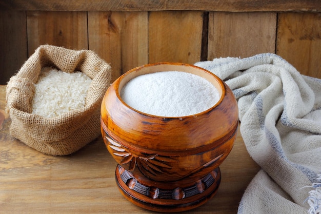 Rauwe biologische rijstmeel in kom over rustieke houten tafel glutenvrij eten