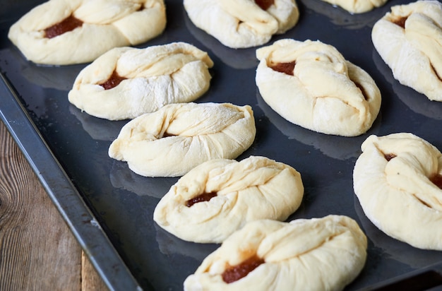 Rauwe broodjes met jam op een bakplaat