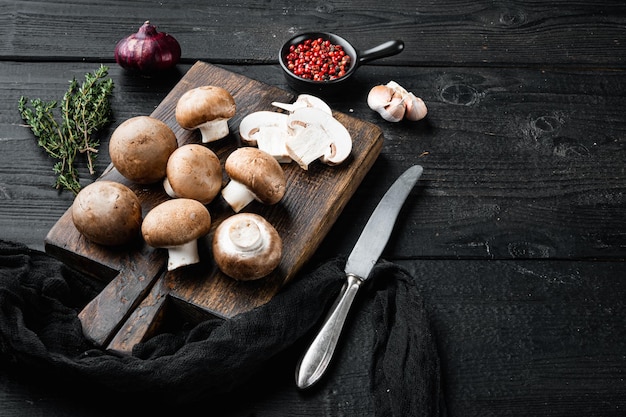 Rauwe champignons champignons set, op zwarte houten tafel achtergrond