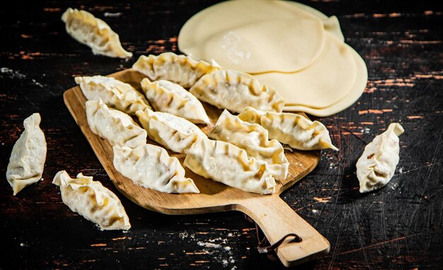 Rauwe dumplings gyoza op een houten snijplank