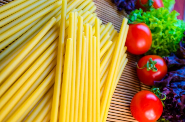 Rauwe en lange pasta en groenten op tafel