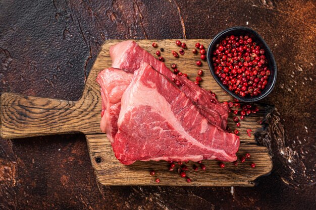 Rauwe entrecote gesneden silverside steak op een houten bord donkere achtergrond bovenaanzicht