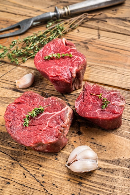 Rauwe filet mignon steaks, ossenhaas op een houten slagertafel met vleesvork. houten achtergrond. Bovenaanzicht.