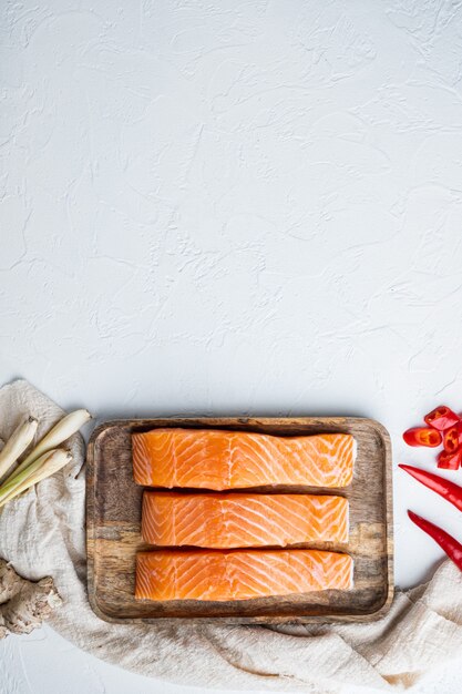 Rauwe forel met kruiden, op witte getextureerde tafel, plat gelegd