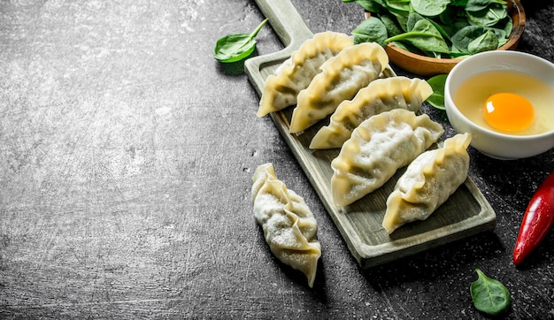 Foto rauwe gedza dumplings met ei en spinazie