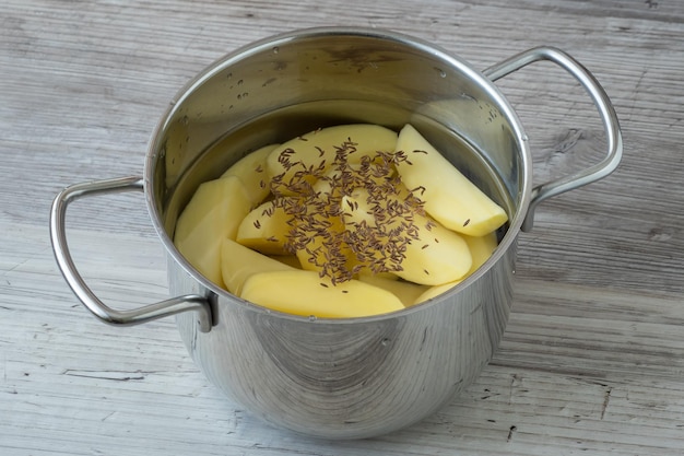 Rauwe geschilde aardappelen in een pan met water voor het koken