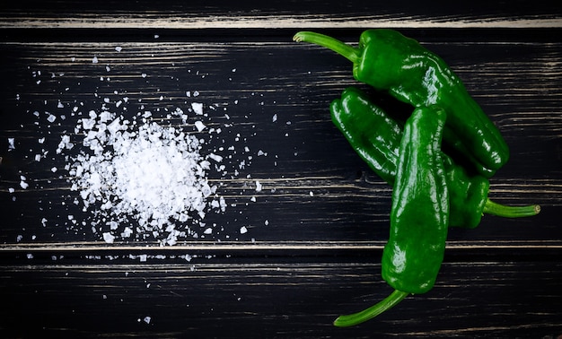 Rauwe groene hete Mexicaanse pepers jalapeno, padron pepers op zwarte houten tafel