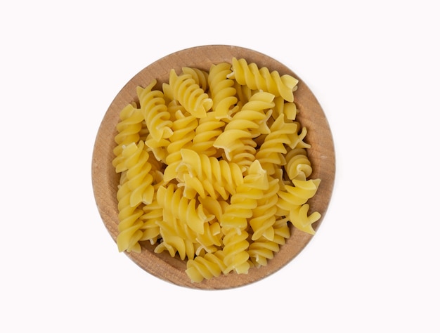 Rauwe Italiaanse pasta in houten kom geïsoleerd op een witte achtergrond, bovenaanzicht