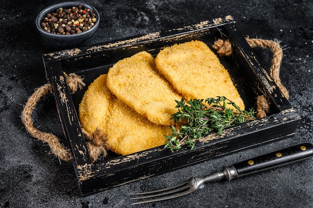 Rauwe kip cordon bleu vleeskoteletten in een houten dienblad met kruiden op houten tafel. Bovenaanzicht.