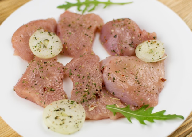 Foto rauwe kipfilet bestrooid met kruiden op een houten ondergrond voorbereiding voor het koken