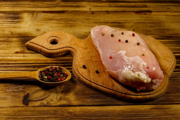 Rauwe kipfilet op snijplank op houten tafel