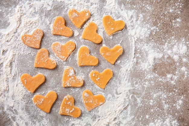 Rauwe koekjes met bloem op grijze tafel