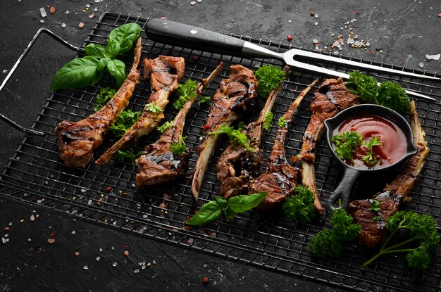 Rauwe lamsribben en kruiden op de grill ter voorbereiding op de barbecue Vlees Bovenaanzicht