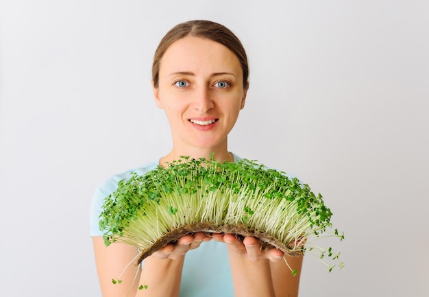 Rauwe microgreens broccoli spruiten in kinderhanden gezond eetconcept Het kind geniet van verse gree