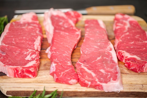 Rauwe New York strip steaks op een houten snijplank.