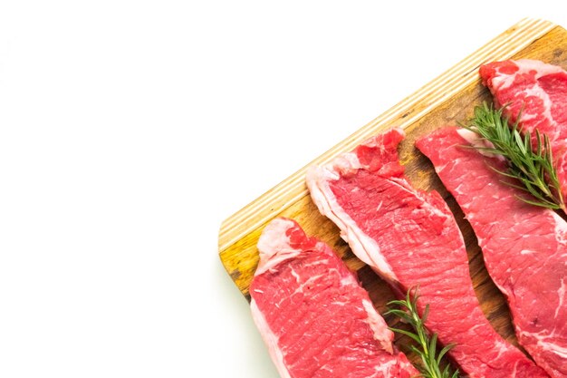 Rauwe New York strip steaks op een houten snijplank.