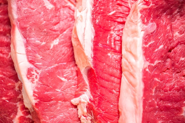 Rauwe New York strip steaks op een witte achtergrond.