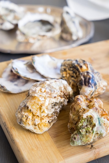 Rauwe oesters met gesloten schelpen op houten plank