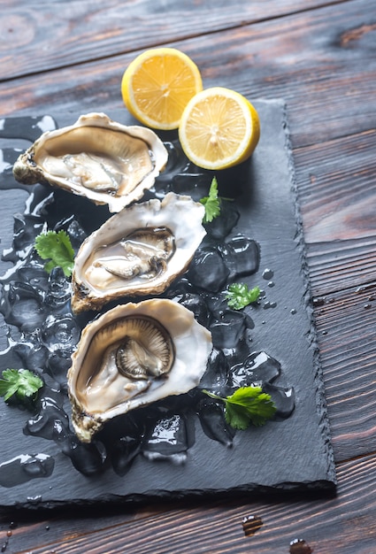 Rauwe oesters op de zwarte stenen bord