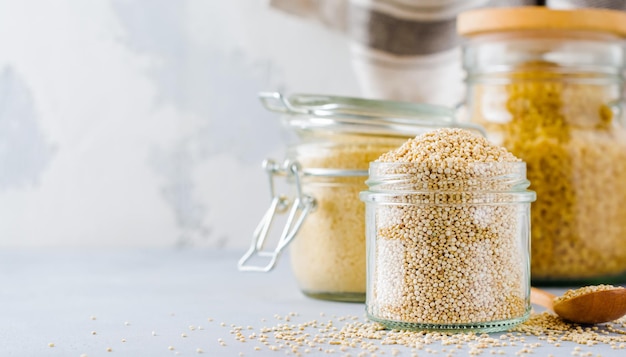 Rauwe quinoa korrels in pot. Gezond vegetarisch eten op grijze keukentafel. Selectieve aandacht.