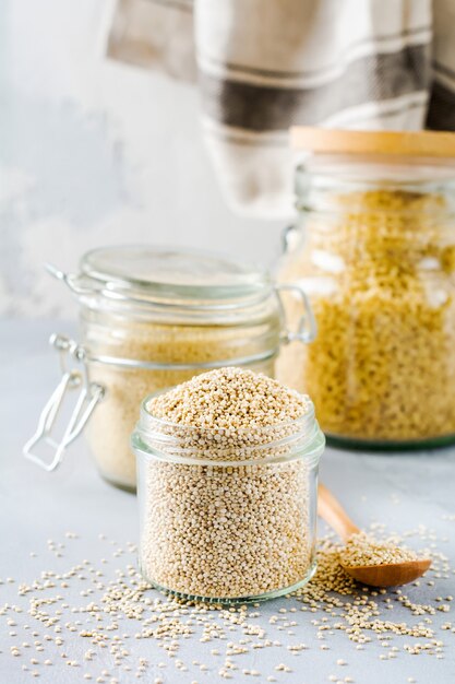 Rauwe quinoa korrels in pot. Gezond vegetarisch eten op grijze keukentafel