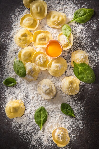 Rauwe ravioli met meel ei paddestoelen en spinazie - Top of view. Italiaanse of mediterrane gezonde keuken.