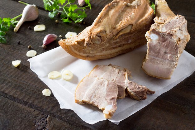 Rauwe reuzel van varkensvlees op een snijplank met knoflook en kruiden