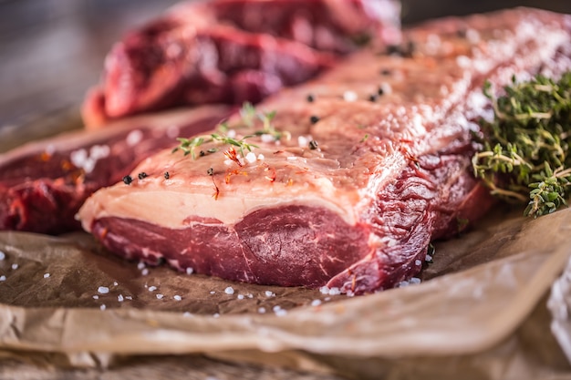 Rauwe rib eye biefstuk met zoute specerijen en kruiden.