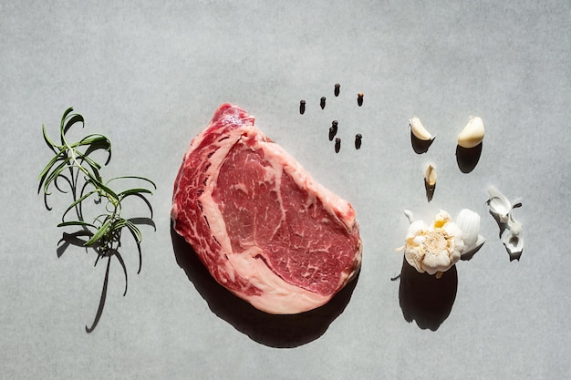 Rauwe ribeye steak met rozemarijn knoflook en peper klaar om te koken