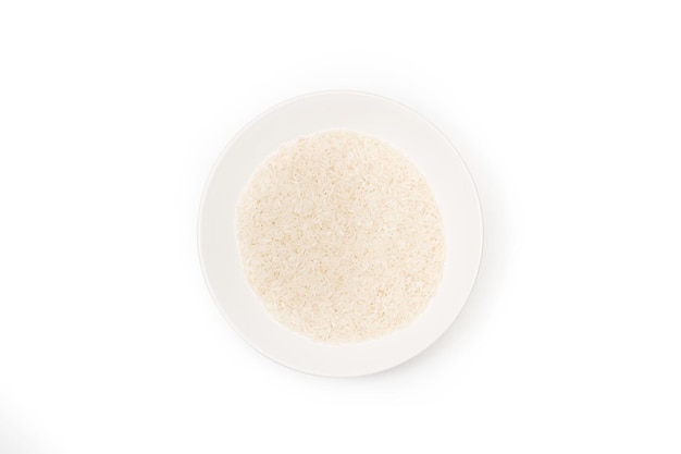 Foto rauwe rijst in een witte plaat op een witte achtergrond in een bovenaanzicht met kopieerruimte