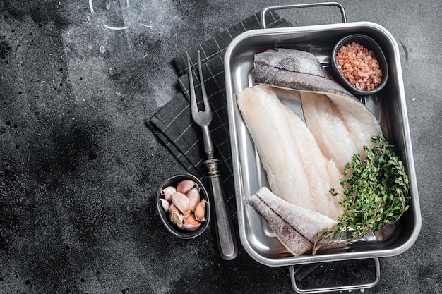 Rauwe schelvisfilets witvisvlees in keukenblad met tijm Zwarte achtergrond Bovenaanzicht Kopieer ruimte