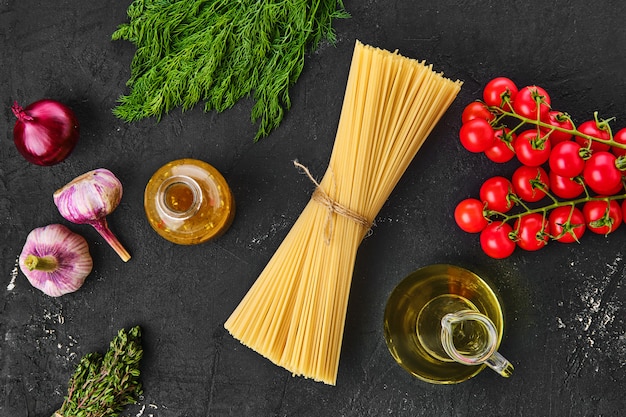 Rauwe spaghetti en groenten op zwarte tafel