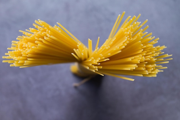 Rauwe spaghetti pasta ongekookte spaghetti noedels op donkere achtergrond rauwe pasta italiaans eten