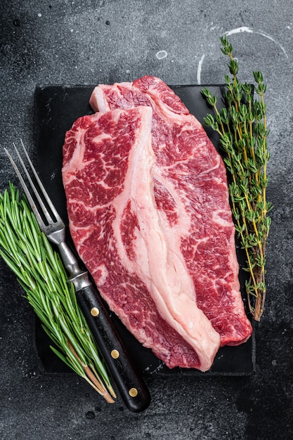Rauwe Striploin steak of New York steak beef vlees gesneden. Zwarte achtergrond. Bovenaanzicht.