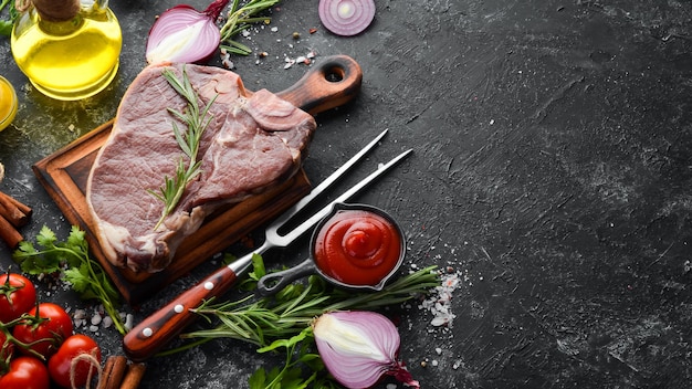 Rauwe Tbone steak op een zwarte stenen tafel Bovenaanzicht Vrije ruimte voor uw tekst