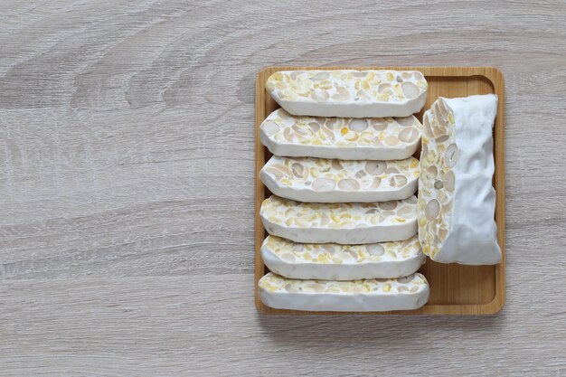 Foto rauwe tempeh bovenbeeld van tempehsnijden in een schaal op houten achtergrond gezond eten concept