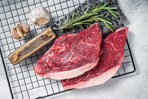 Rauwe top entrecote biefstuk op een slager hakmes GLB rumpsteak Witte achtergrond Bovenaanzicht